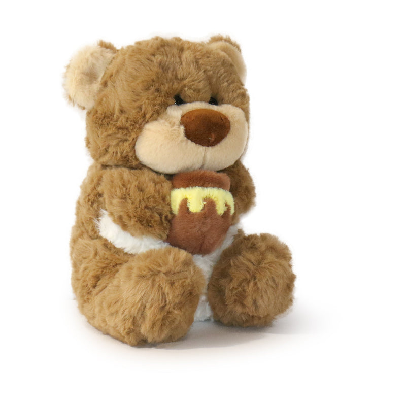 Plush bear toy holding a honeycomb on a white background