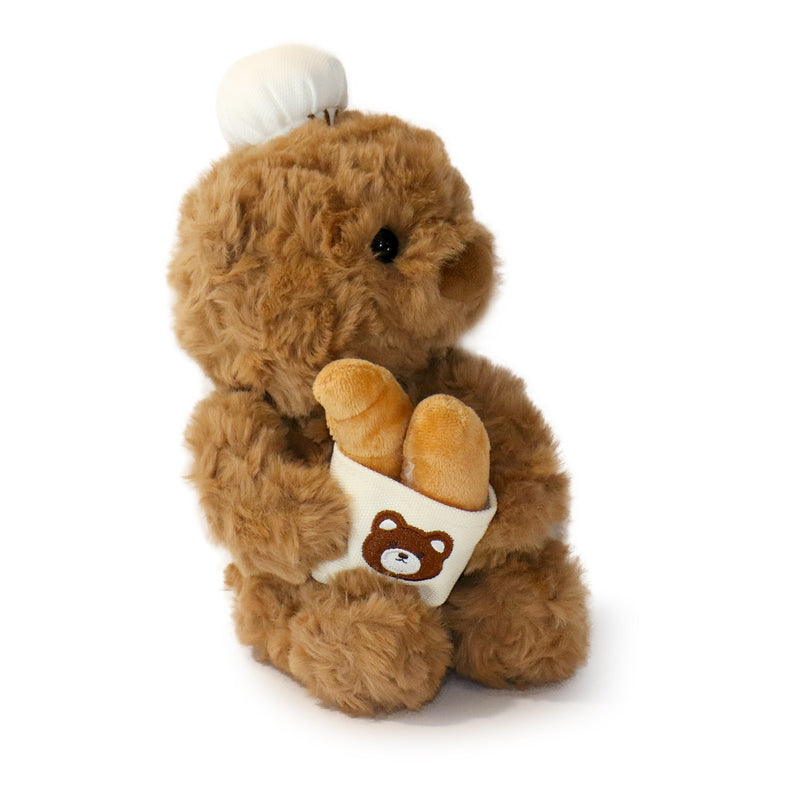Brown teddy bear holding a white bag with a brown bear emblem on a white background