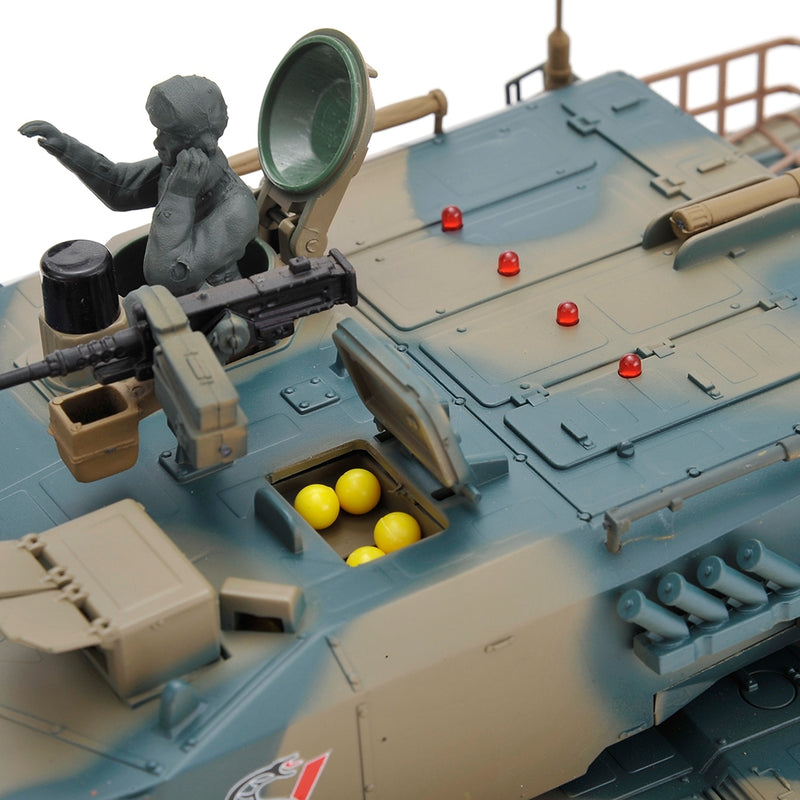 Toy tank model with a figure inside, yellow balls in a compartment, and red lights on the turret.