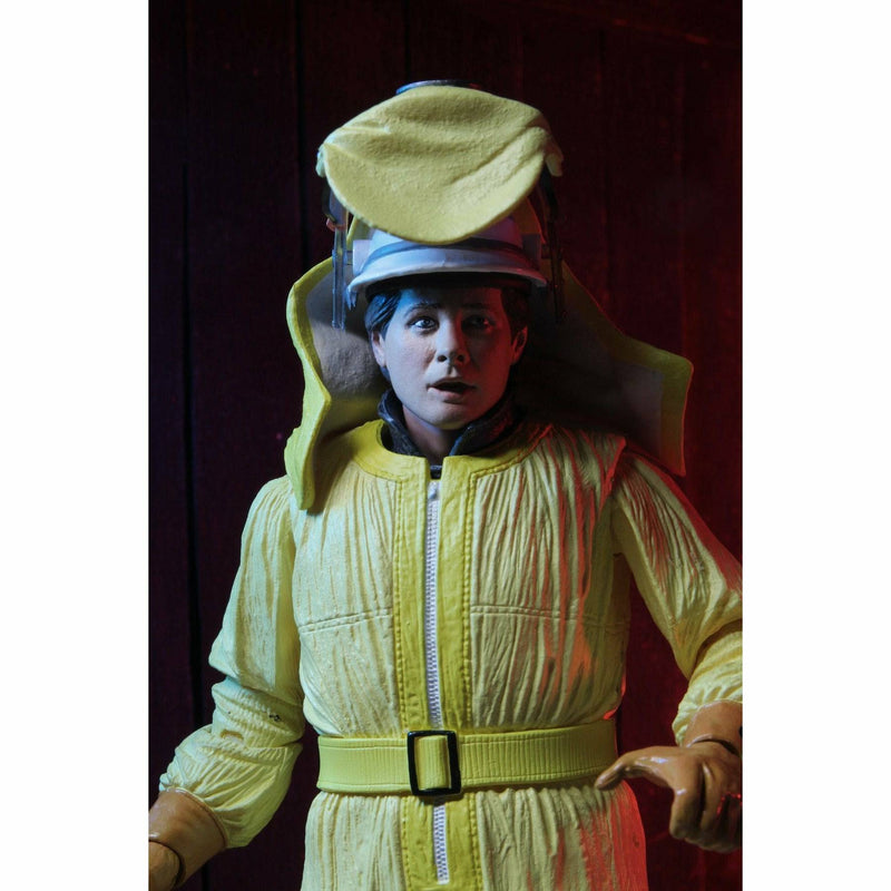 Person wearing a bright yellow space suit with a helmet against a dark background