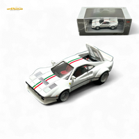 White model car with red and green stripes on a white background, accompanied by its packaging.