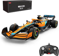 Orange and black toy Formula 1 car with remote control and packaging on a white background