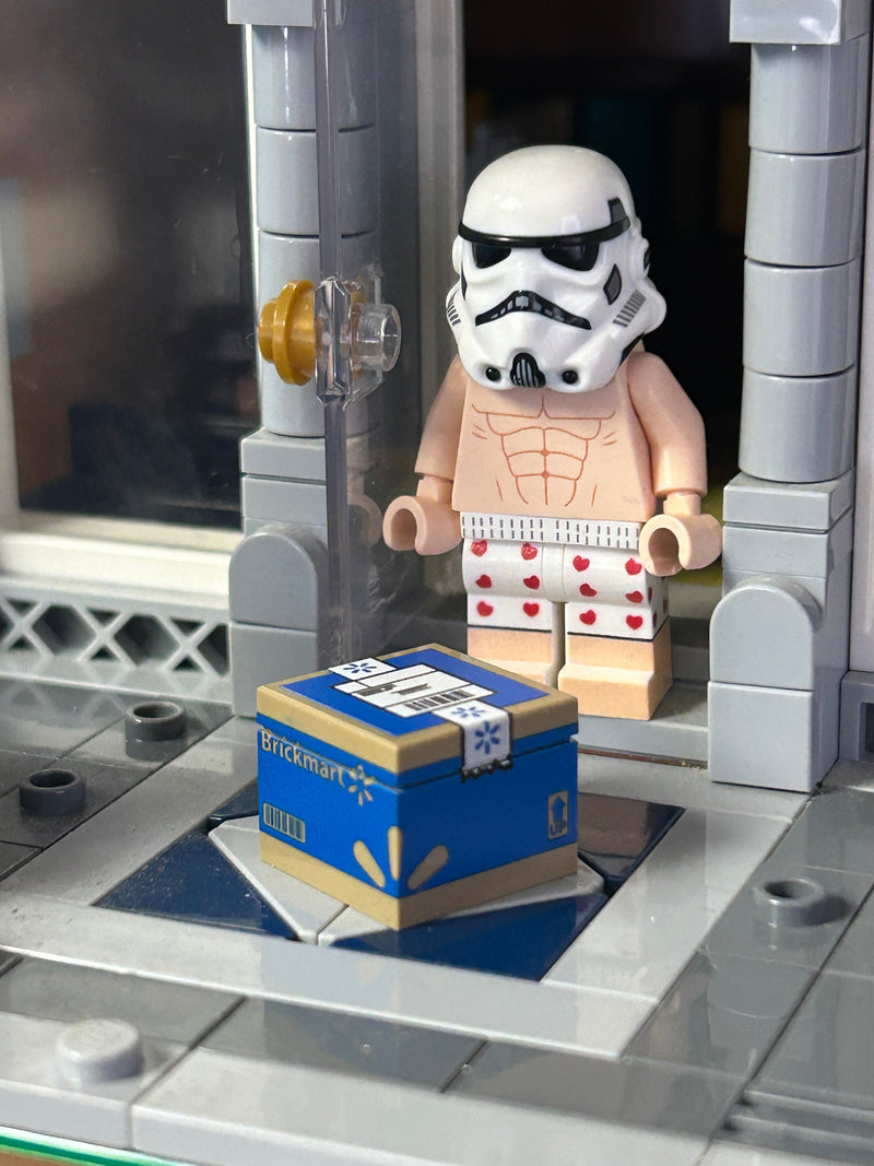 LEGO stormtrooper minifigure with a box labeled 'Brickmart' on a gray platform.