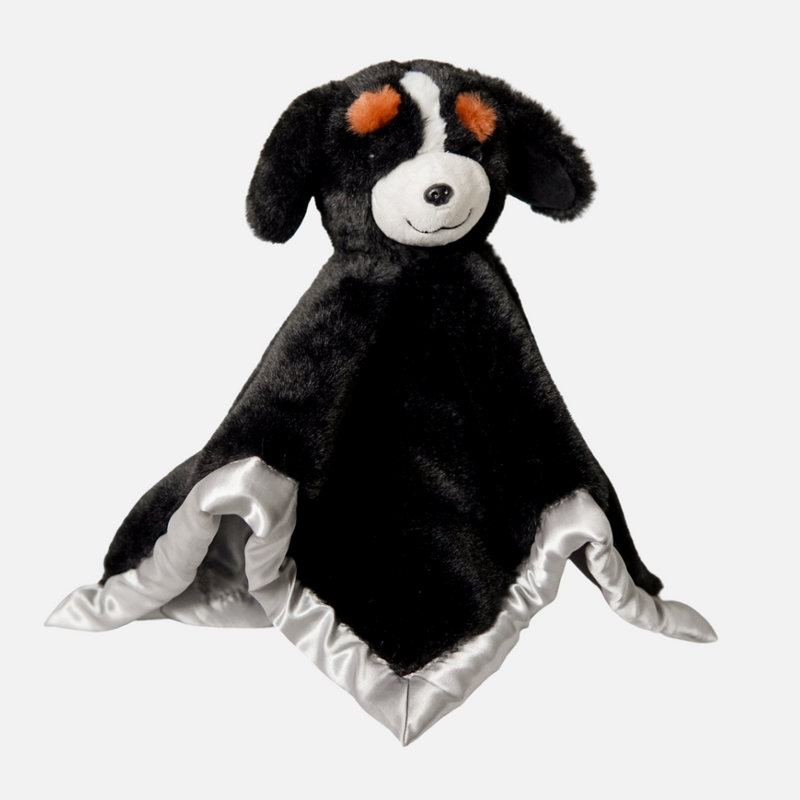 Black plush dog toy with white accents on a light gray background