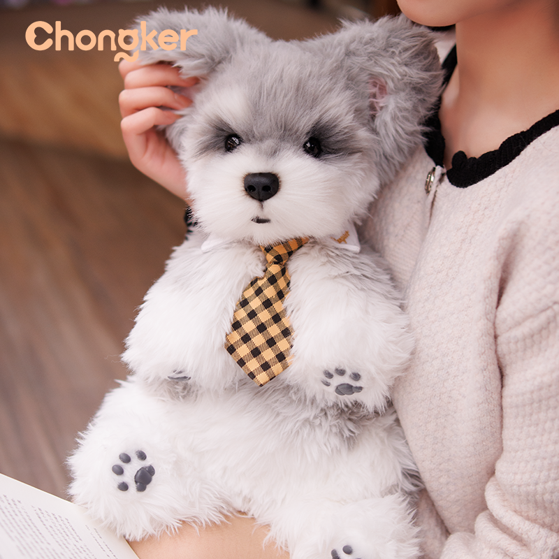 Plush toy dog with a checkered tie held by a person, with 'Chongker' branding.