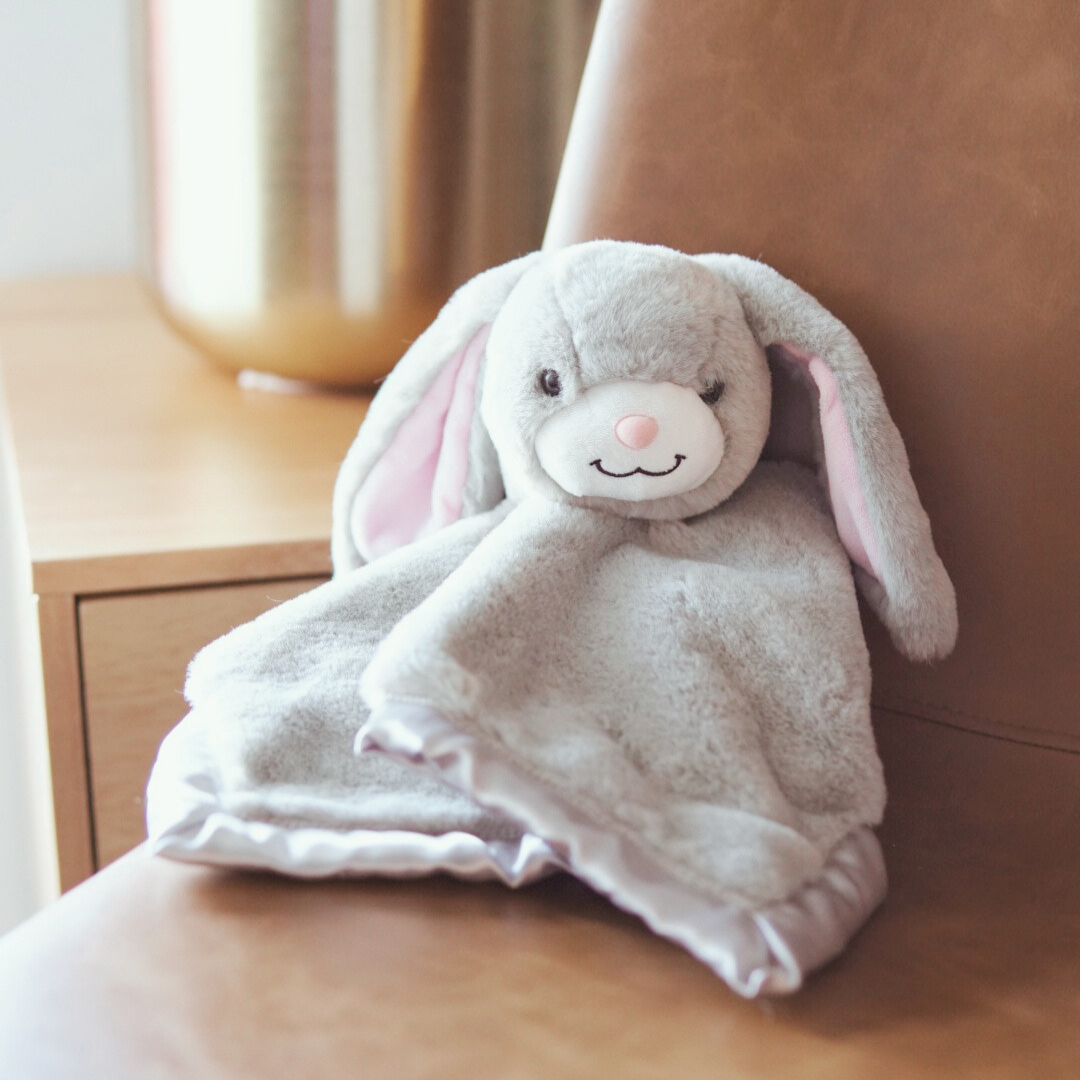 Gray bunny plush toy on a wooden surface