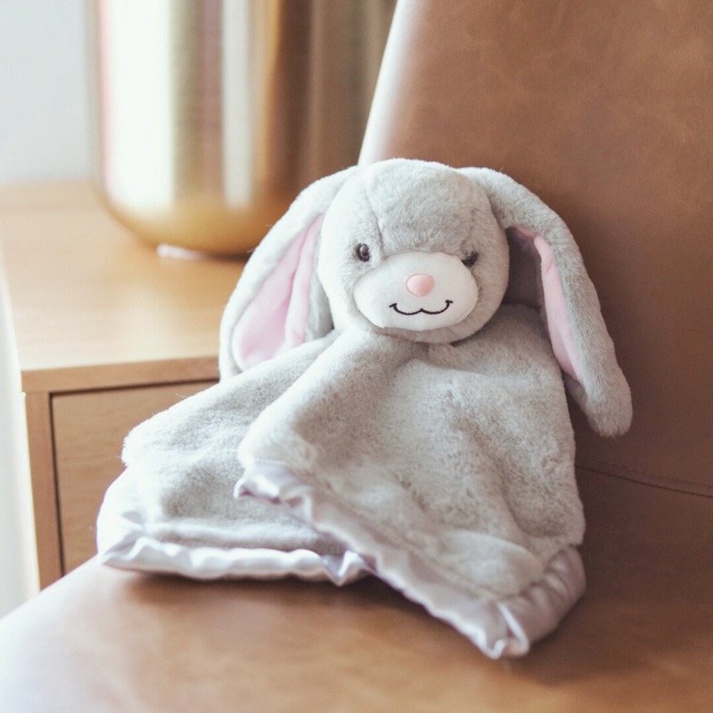 Gray bunny plush toy on a wooden surface