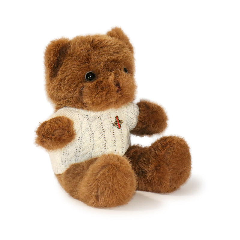 Brown teddy bear wearing a white sweater with a red heart on a white background