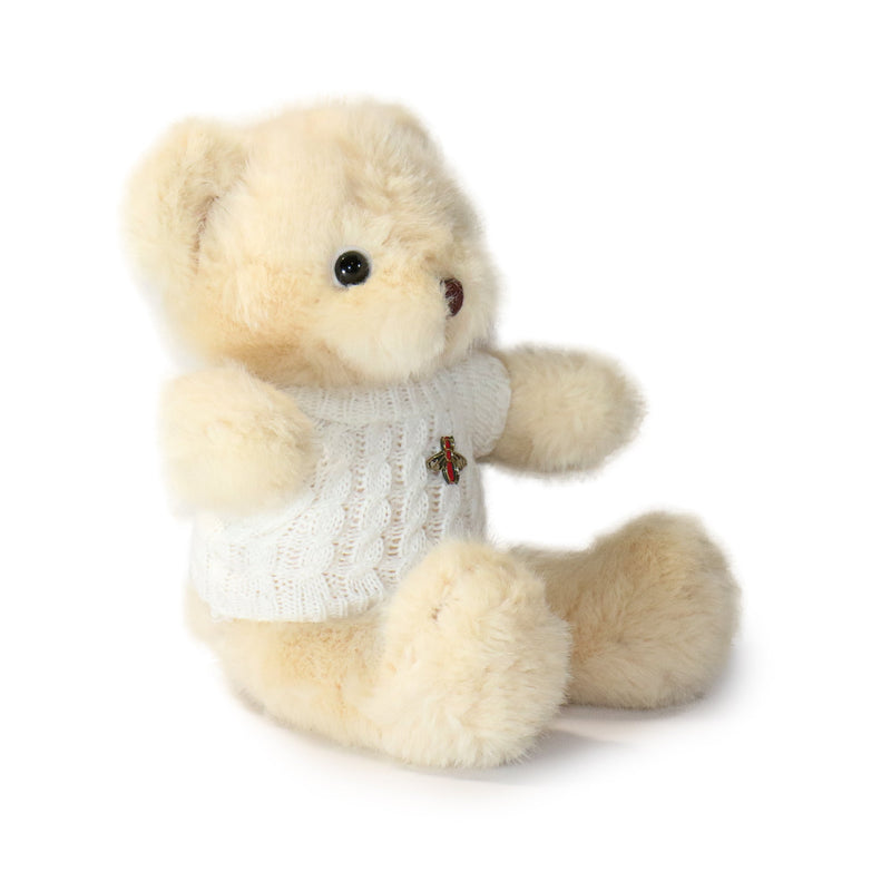 Plush teddy bear wearing a white sweater on a white background