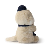 Plush toy otter with a navy hat and collar on a white background