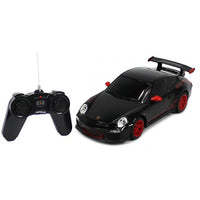 Black toy car with red accents and a remote control on a white background
