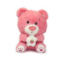 Pink teddy bear with a white belly and red heart on a white background
