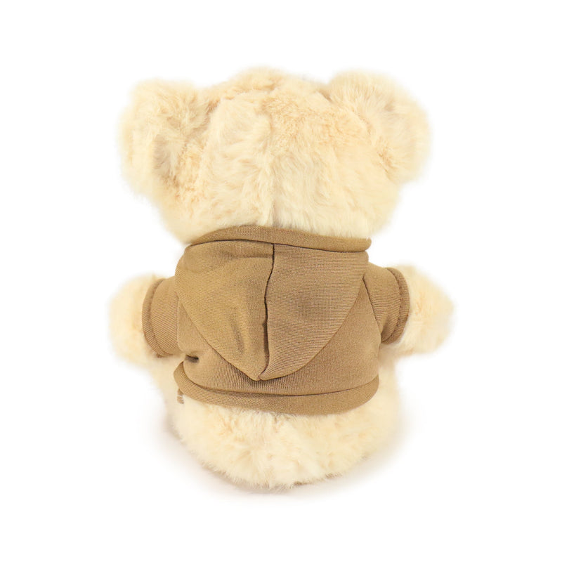 Plush toy bear wearing a beige coat with fur trim on a white background