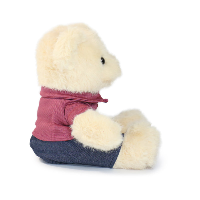 Stuffed animal wearing a pink shirt and blue pants on a white background