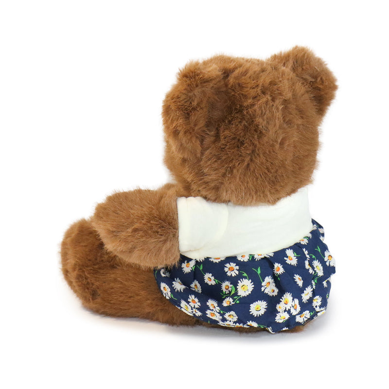 Brown teddy bear wearing a navy diaper with white floral pattern on a white background