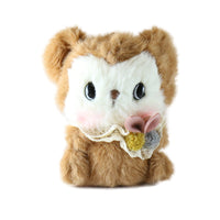 Plush toy resembling a small animal with a white face and brown body on a white background