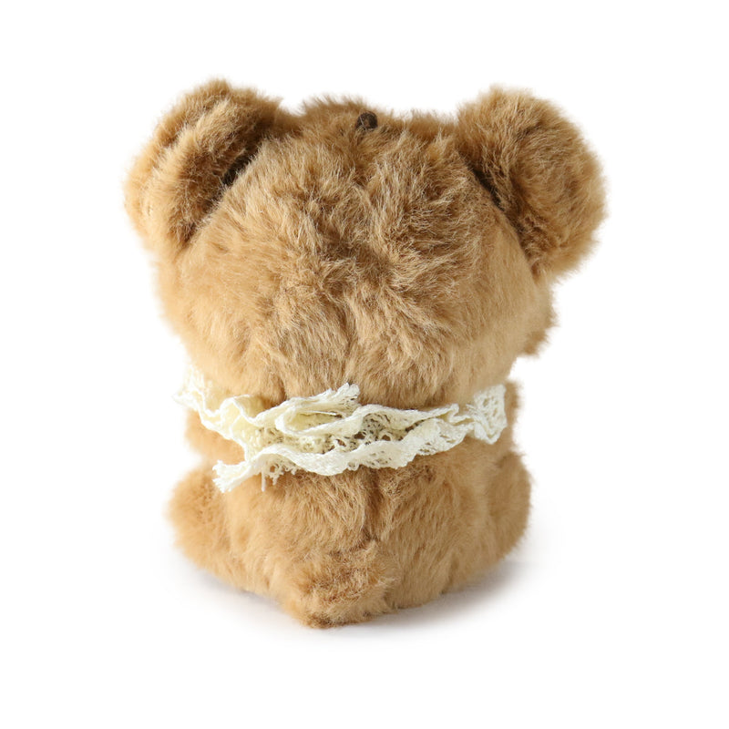 Brown teddy bear with a white lace bow on a white background