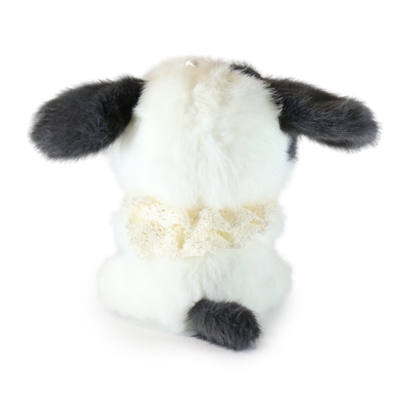 Plush toy cow with black ears and hooves on a white background