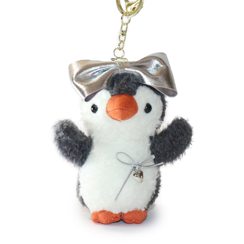 Plush penguin keychain with a silver bow on a white background