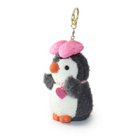Plush penguin keychain with pink hat and heart on a white background