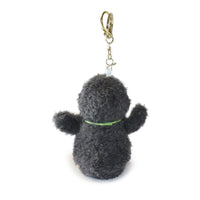 Plush keychain shaped like a dog with a green collar on a white background