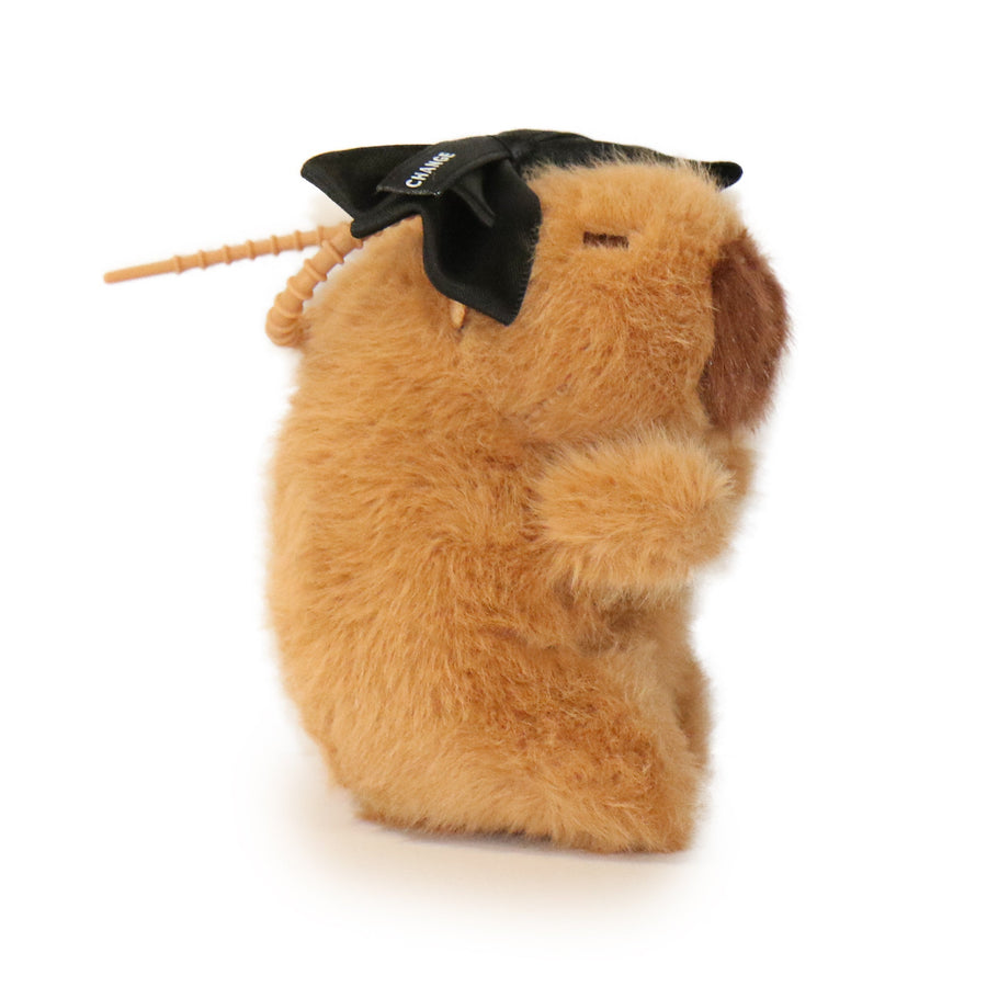 Plush toy resembling a guinea pig with a black bow on a white background