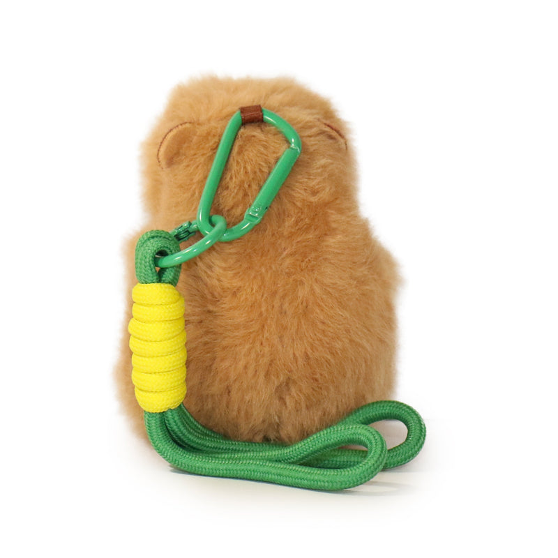 Brown plush toy with a green rope and yellow handle on a white background