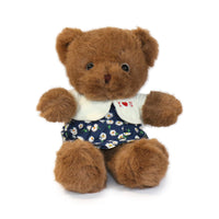 Brown teddy bear wearing a white shirt with 'I ❤️ U' and a navy skirt with floral pattern on a white background.
