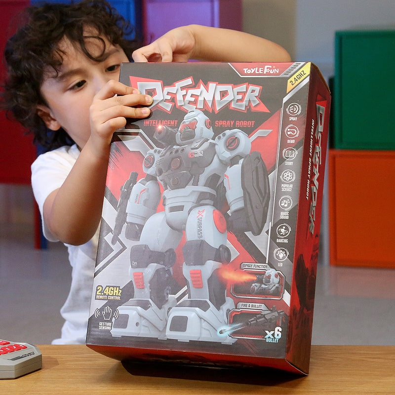A young boy holding the Defender intelligent spray robot toy packaging