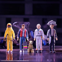 Five action figures in various outfits with a blurred background
