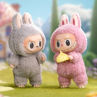 Two cartoon characters in bunny costumes standing on a grassy area with a blurred background.