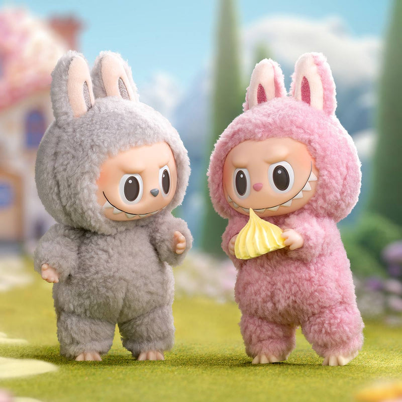Two cartoon characters in bunny costumes standing on a grassy area with a blurred background.
