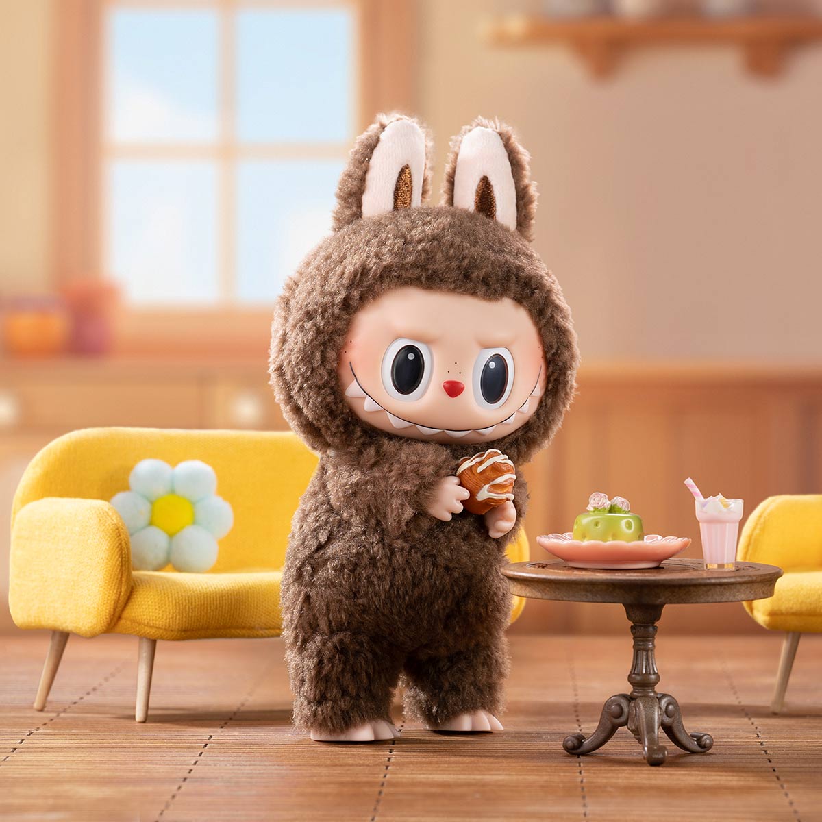 Plush toy in a brown costume with bunny ears standing in a room with yellow chairs and a small table.