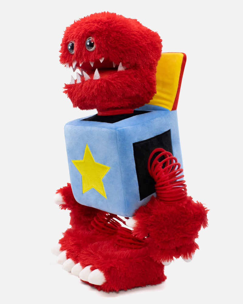 Red plush toy with a blue block featuring a yellow star on a white background