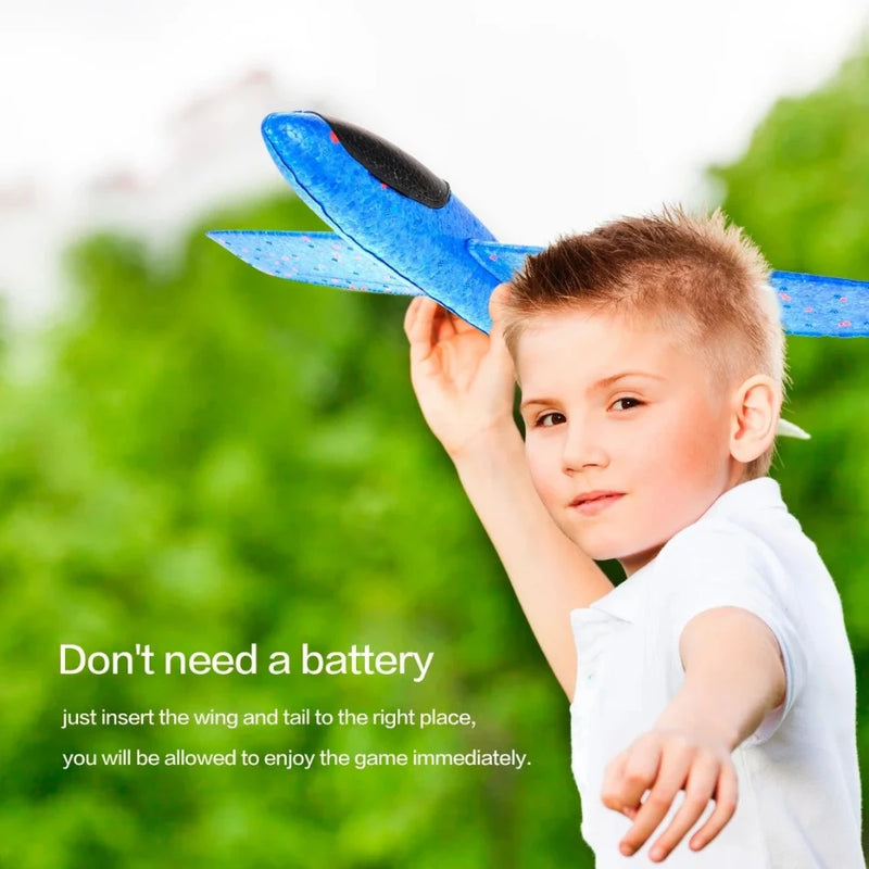 Young boy holding a blue airplane toy, enjoying battery-free fun with easy assembly