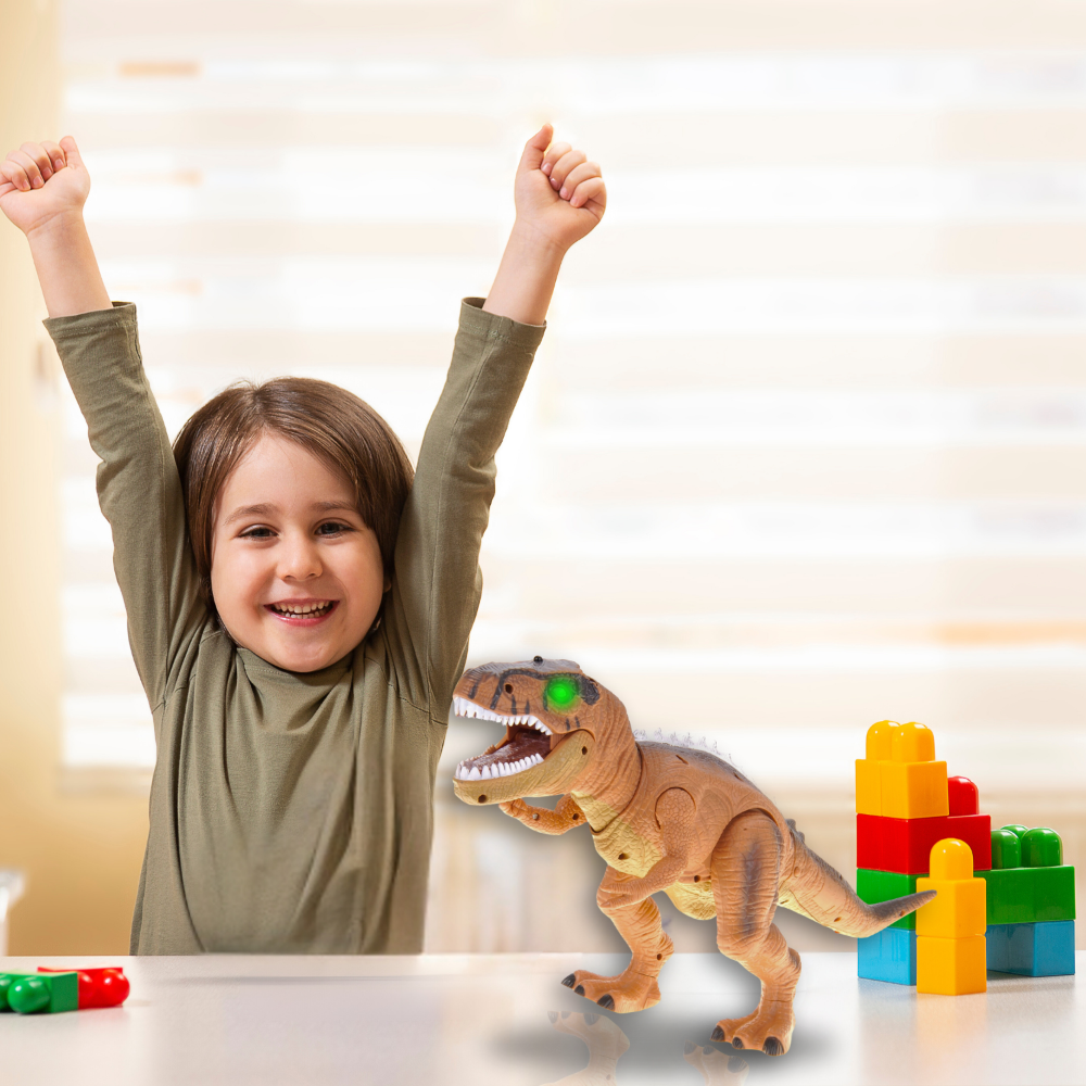 Smiling child playing with a remote-control dinosaur toy on a table surrounded by colorful building blocks.
