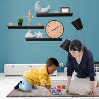 Child playing with a remote control dump truck toy alongside a parent in a playroom setting