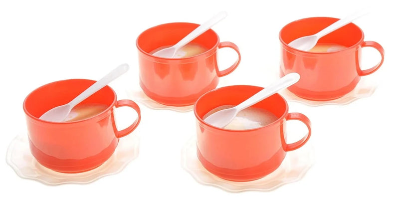 Set of red toy cups with white spoons on white saucers, part of a children's tea party play set.