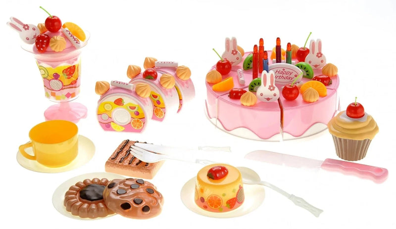 DIY fruit cake toy set laid out with cake, utensils, and dessert items for pretend play
