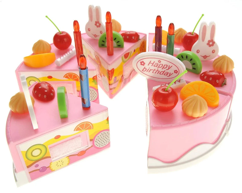 Close-up of DIY fruit cake toy set with decorated cake slices, candles, and fruit toppings