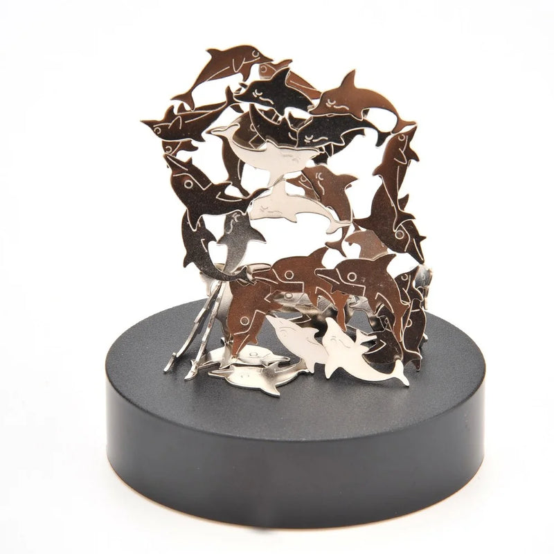 Close-up of dolphin magnetic sculpture toy arranged creatively on a black platform for stress relief.