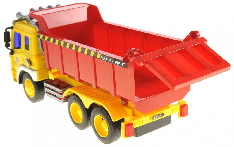 Back view of a large yellow dump truck toy with red container, featuring 'Safety First' markings
