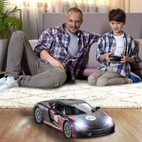 Father and son playing with Porsche 918 Spyder remote control car, enjoying family bonding time