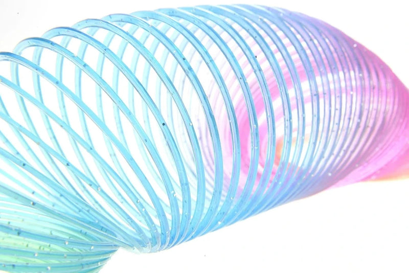 "Close-up of flexible plastic rainbow spring with glitter details, designed for endless twisting and fun.