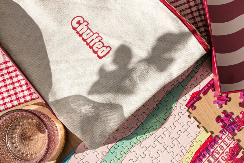 Close-up of a 'Chuffed' shirt with a puzzle and decorative items on a table.
