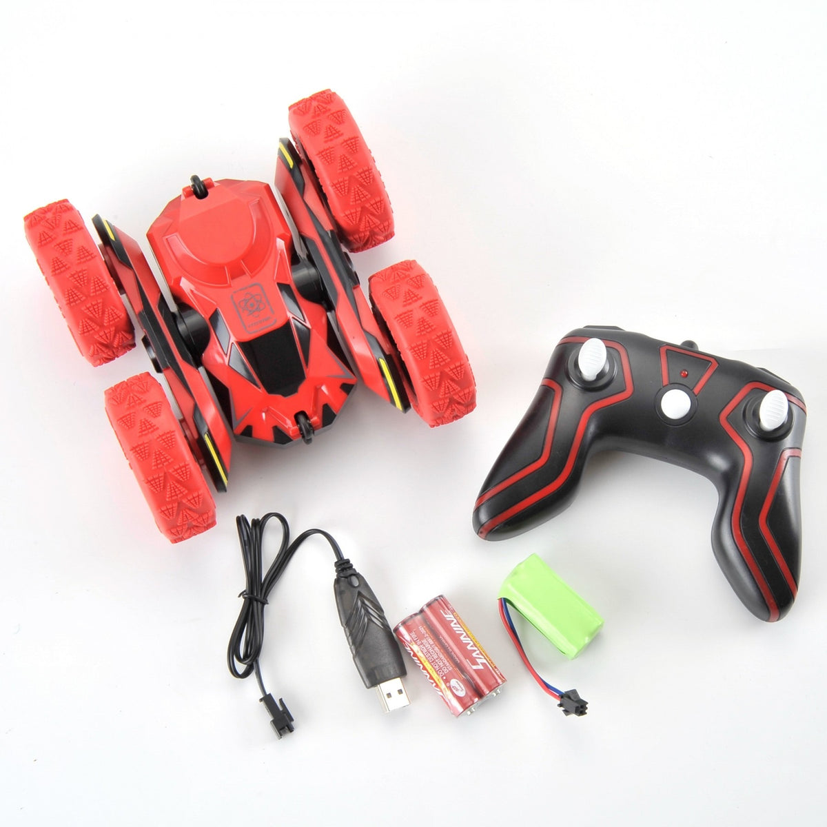 Red toy vehicle with black remote control, USB cable, and batteries on a white background