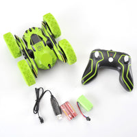 Green and black remote control car with controller and accessories on a white background