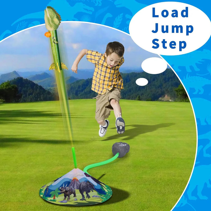 A child launching a dinosaur rocket toy by jumping on the air pump in a scenic outdoor setting.