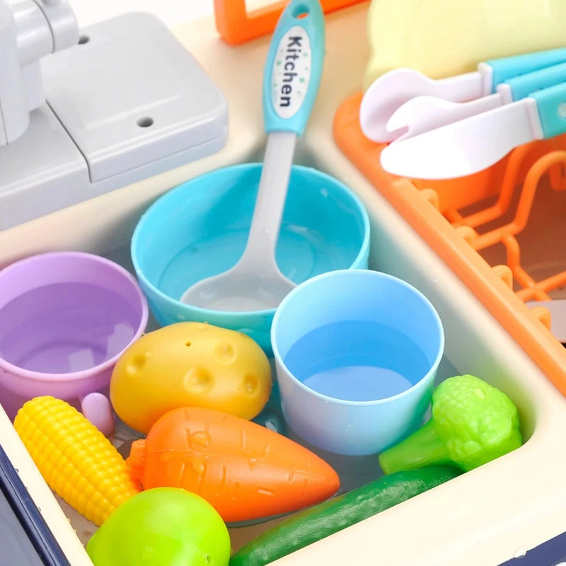 Kids’ kitchen playset featuring toy vegetables, cups, and kitchenware in the sink.
