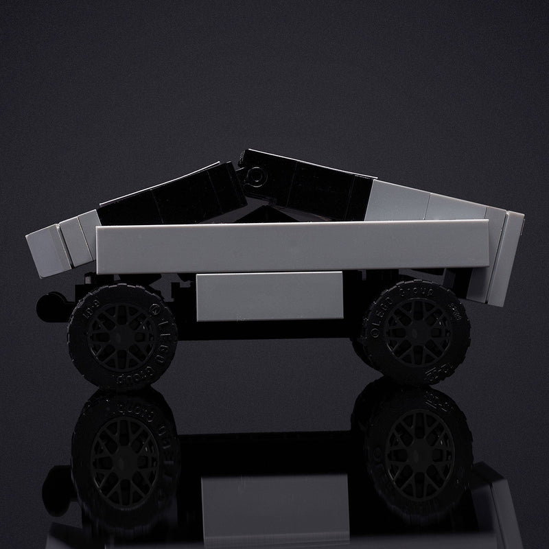 Toy truck made of interlocking bricks on a reflective surface with a dark background